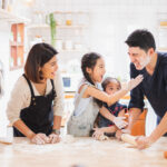 Family enjoy playing and cooking food in kitchen at home